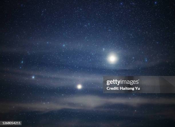 bright jupiter and saturn shining above clouds - jupiter stock-fotos und bilder