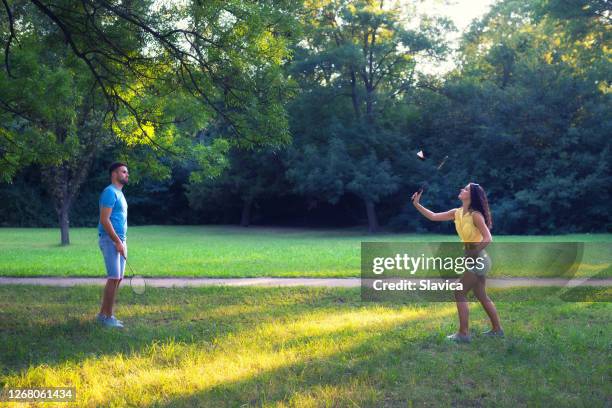 paar spielt badminton im park - playing badminton stock-fotos und bilder