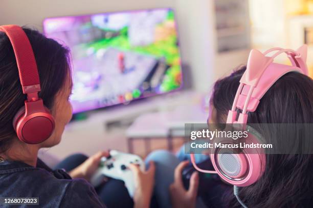 mother and daughter playing video games together - massively multiplayer online game stock pictures, royalty-free photos & images