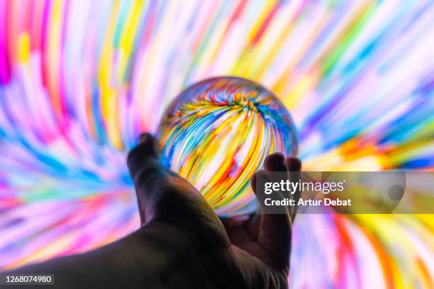 holding a crystal ball through colorful background at night. - lenses imagens e fotografias de stock