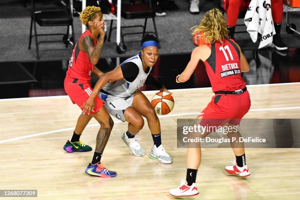 Odyssey Sims of the Minnesota Lynx dribbles the ball as Courtney Williams and Blake Dietrick of the Atlanta Dream defends during the first half at...