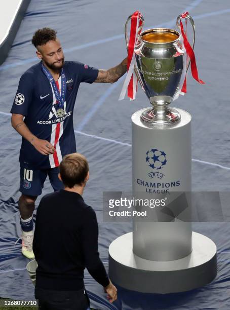 Neymar of Paris Saint-Germain touches the UEFA Champions League Trophy as he looks dejected with his runners up medal following his team's defeat in...