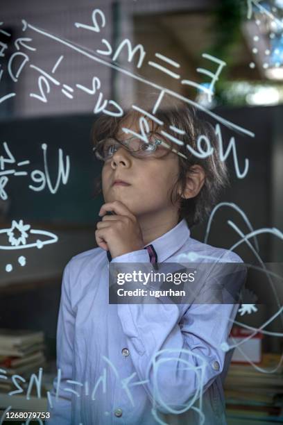 genius boy writes formulas on the window. - genius stock pictures, royalty-free photos & images