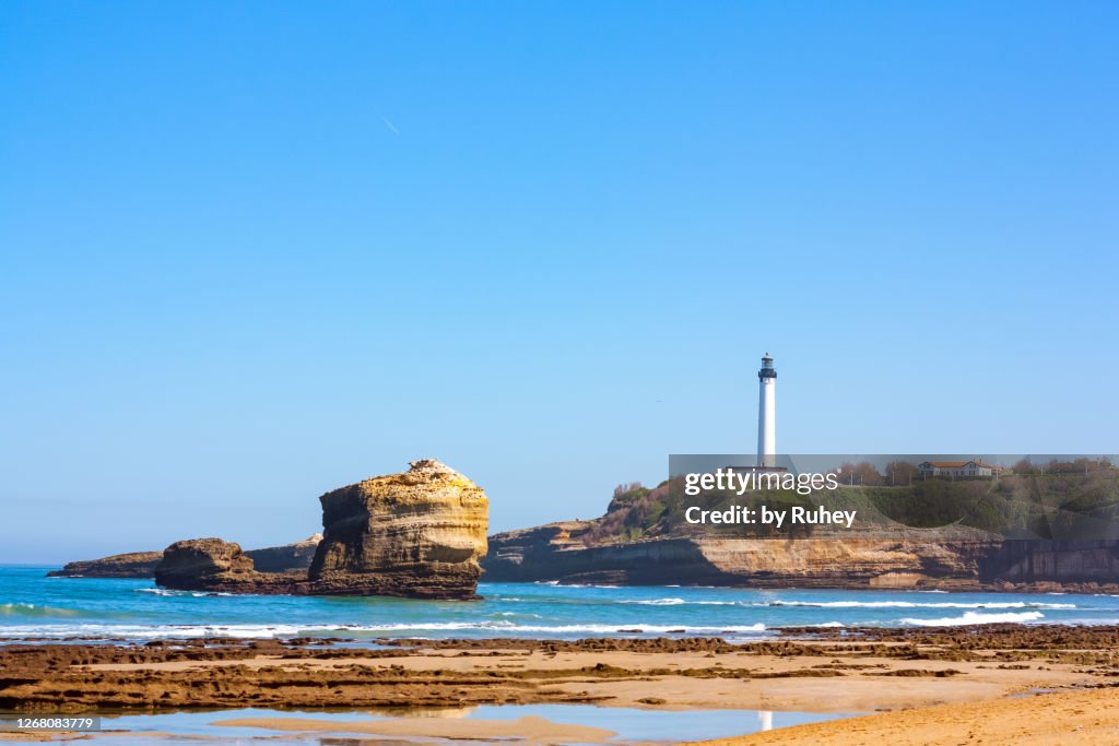 Miramar beach in Biarritz with the lighthouse in the background and the reflection of the sea with its characteristic rock in the foreground