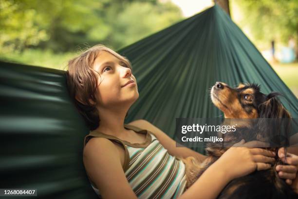 jongen die in hangmat met haar hond ontspant - alleen één jongen stockfoto's en -beelden