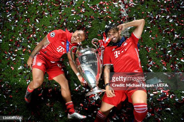 Thiago Alcantara and Javi Martinez of FC Bayern Munich celebrate with the UEFA Champions League Trophy following their team's victory in the UEFA...