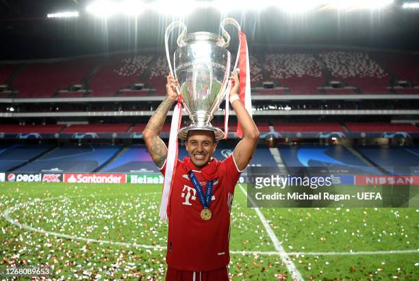 Thiago Alcantara of FC Bayern Munich celebrates with the UEFA Champions League Trophy following his team's victory in the UEFA Champions League Final...