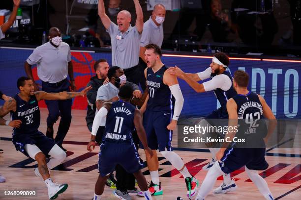Luka Doncic of the Dallas Mavericks celebrates a game winning three point basket with teammates against the LA Clippers during overtime in Game Four...