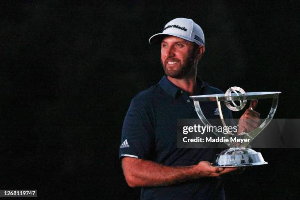 Dustin Johnson of the United States celebrates with the trophy after going 30-under par to win during the final round of The Northern Trust at TPC...