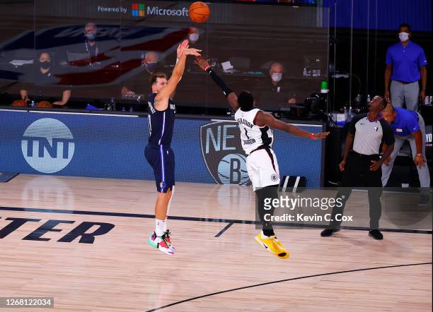 Luka Doncic of the Dallas Mavericks hits a game winning three point basket against Reggie Jackson of the LA Clippers during overtime in Game Four of...