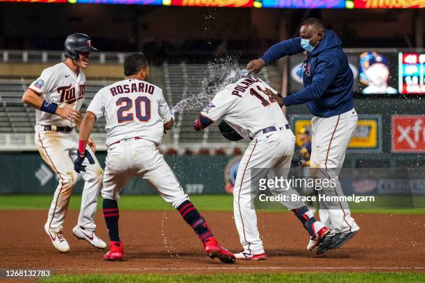 Jorge Polanco of the Minnesota Twins celebrates his walk-off hit with Miguel Sano, Eddie Rosario and Max Kepler against the Milwaukee Brewers on...