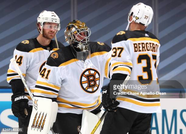 Patrice Bergeron of the Boston Bruins celebrates with goaltender Jaroslav Halak after they defeated the Tampa Bay Lightning 3-2 in Game One of the...