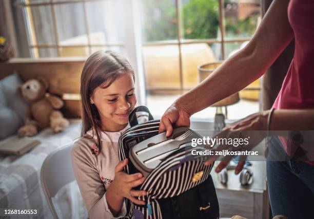 het maken van school lunchbox - packing kids backpack stockfoto's en -beelden