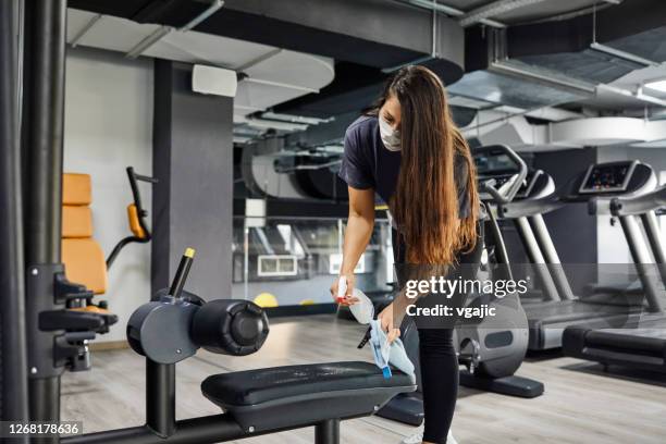 staff disinfecting sports equipment in the gym - gym reopening stock pictures, royalty-free photos & images