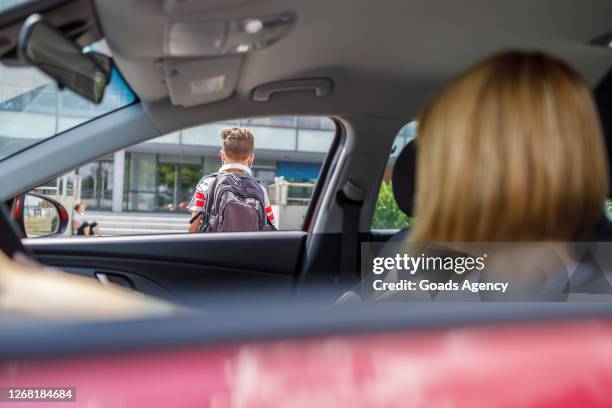 frau in einem auto beobachtet ihren sohn in die schule - young child car driving stock-fotos und bilder