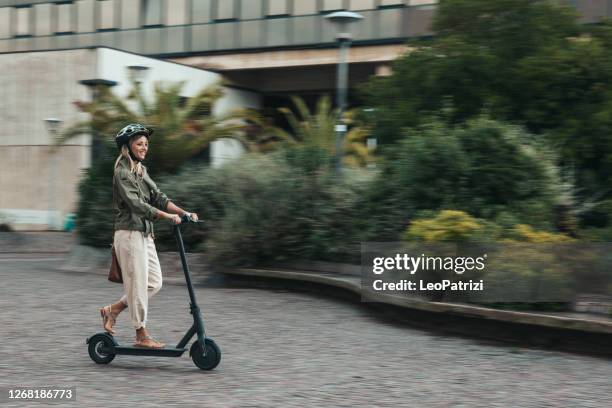 green mobility in the city; woman commuting to work - push scooter stock pictures, royalty-free photos & images