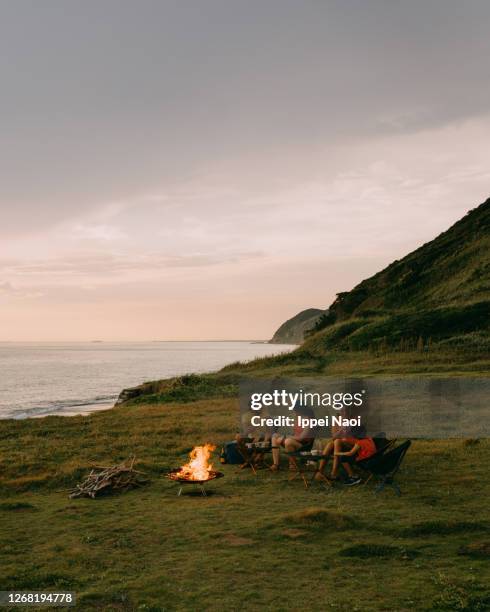 family toasting at campsite by the sea at sunset - couple paysage asie photos et images de collection