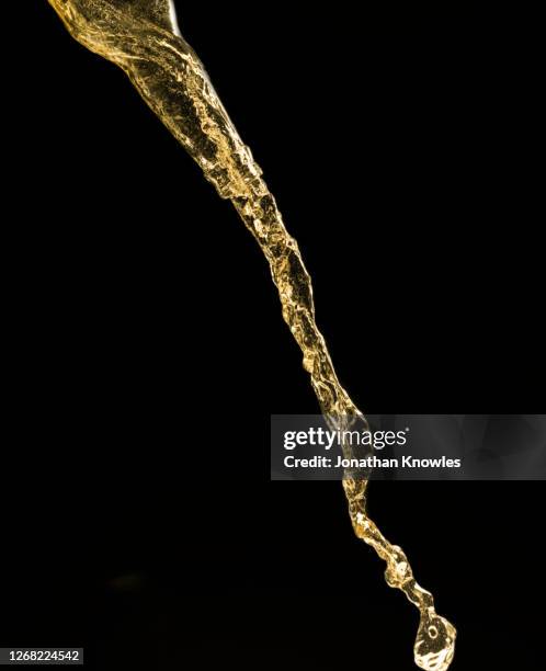 beer pour against black background - pouring fotografías e imágenes de stock