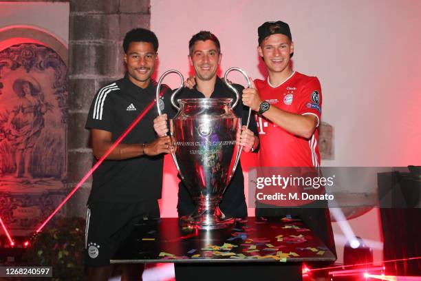 Serge Gnabry, Marco Neppe and Joshua Kimmich of FC Bayern Muenchen pose with the trophy during the banquet after winning the UEFA Champions League...