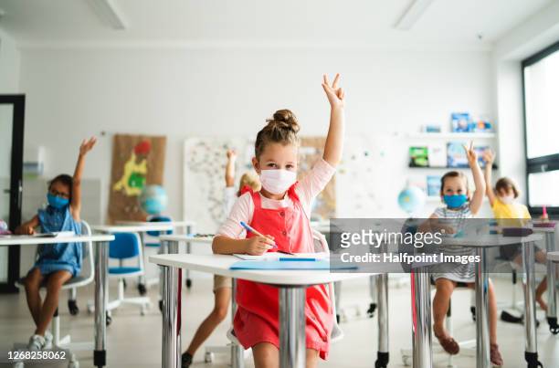 small children with face mask back to school after coronavirus quarantine, learning. - unterrichten stock-fotos und bilder