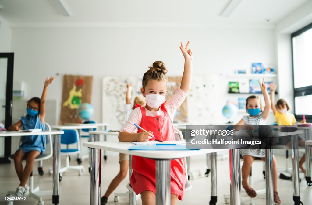 Small children with face mask back to school after coronavirus quarantine, learning.