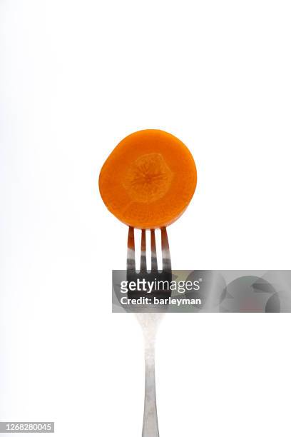 close up of carrot on forks against white background - carrot isolated stock pictures, royalty-free photos & images