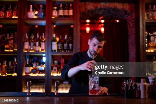 bar man making a delicious cocktail. - steel bar stock-fotos und bilder