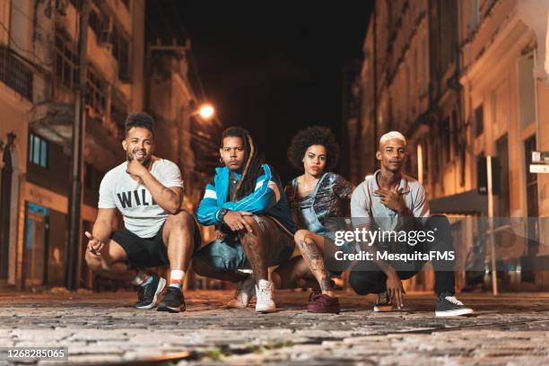 people squatting on the street looking at camera - funky imagens e fotografias de stock