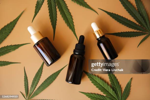 glass bottles with cbd oil, thc tincture and hemp leaves on a marble background. flat lay cosmetics cannabis oil. health, ganja. - cbd oil stock pictures, royalty-free photos & images