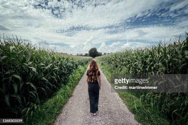 beautiful woman walk on a long path - single lane road stock pictures, royalty-free photos & images