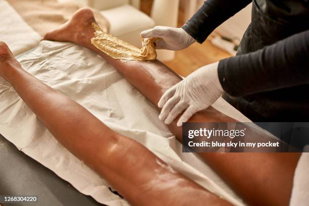 a beautician at work on a clients legs - depilação de pernas com cera - fotografias e filmes do acervo