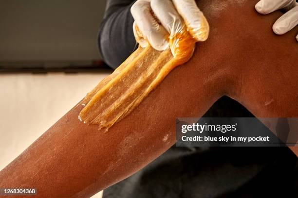 a beautician at work on a clients legs - wax stock pictures, royalty-free photos & images