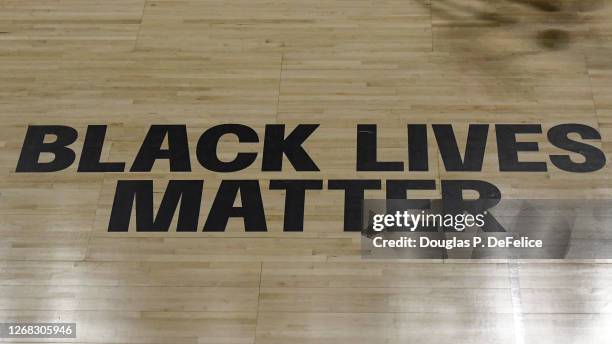 General view of the shadow of a player dribbling a ball on the court past the Black Lives Matter sign on the court during the second half of the game...
