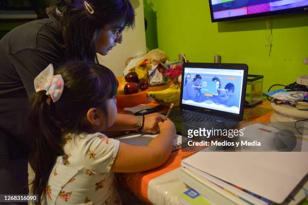 Student takes classes on a laptop and receives help from her older sister during the start of the school year from home on August 24, 2020 in...