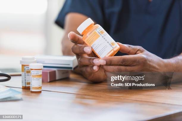 home healthcare nurse reviews medication with patient - prescription label stock pictures, royalty-free photos & images