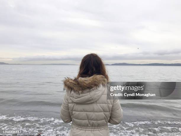 girl standing on the shores of puget sound - young gray stock pictures, royalty-free photos & images