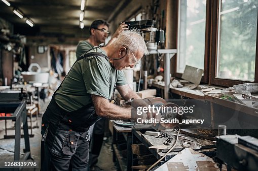Two senior men working together in workshop Two senior men working together in workshop