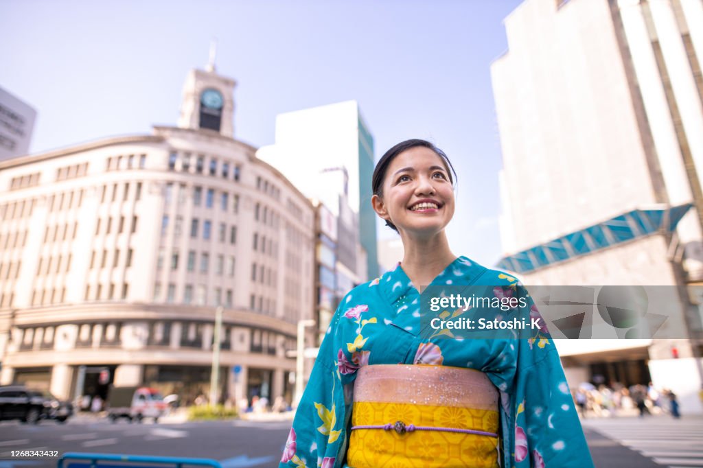 Young woman in yukata walking in urban city