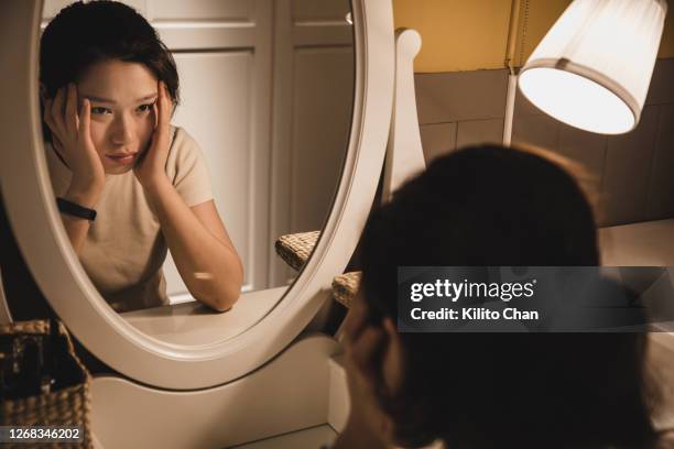 asian woman sitting in front of the dressing table feeling depressed - 鏡台 ストックフォトと画像