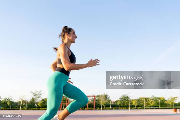 athlete woman running at sunset - gluteos fotografías e imágenes de stock