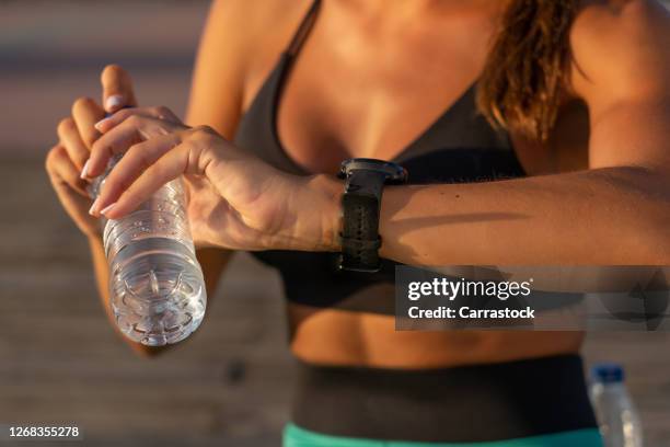 athlete woman consulting sports watch. - marathon zuschauer stock-fotos und bilder