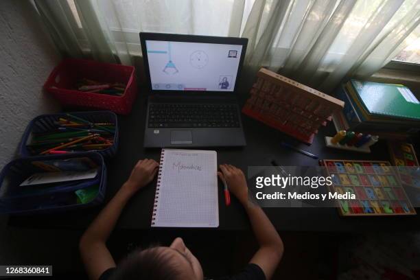 Pupil takes notes in a notebook during the start of the school year from home on August 24, 2020 in Cancun, Mexico. Mexican government will not allow...