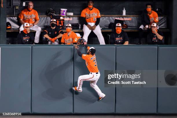 Cedric Mullins of the Baltimore Orioles attempts to make a play on a ball that is hit into the bullpen for a home run by Jackie Bradley Jr. #19 of...