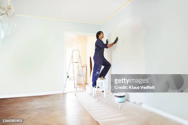 man applying plaster on wall of room - applying plaster stock pictures, royalty-free photos & images