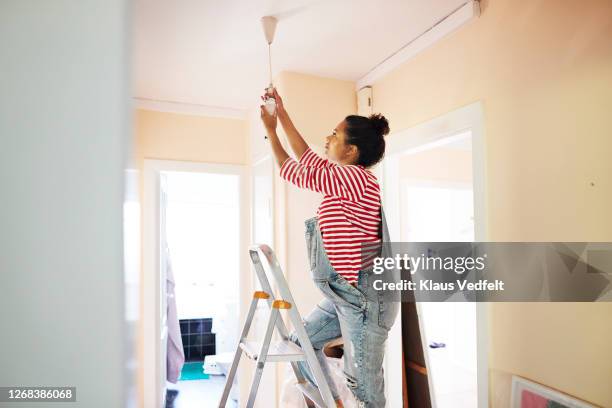 pregnant young woman renovating home - step ladder stock-fotos und bilder