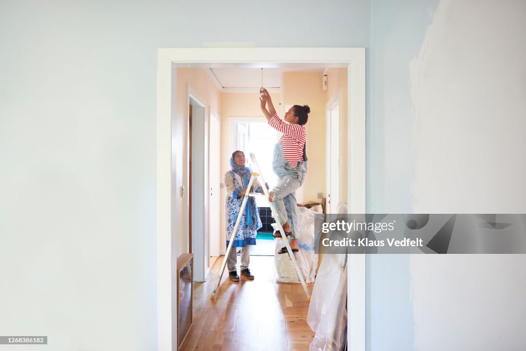 Woman helping daughter-in-law in home renovation