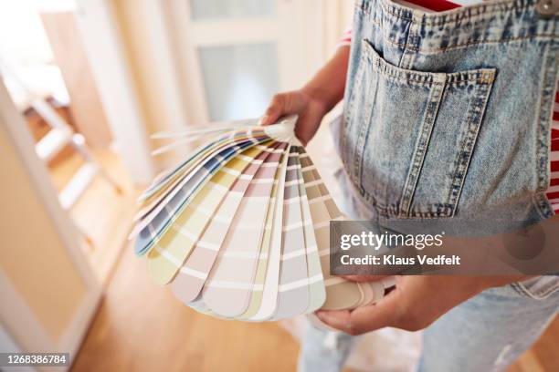 woman choosing paint color during home renovation - campione di colore foto e immagini stock