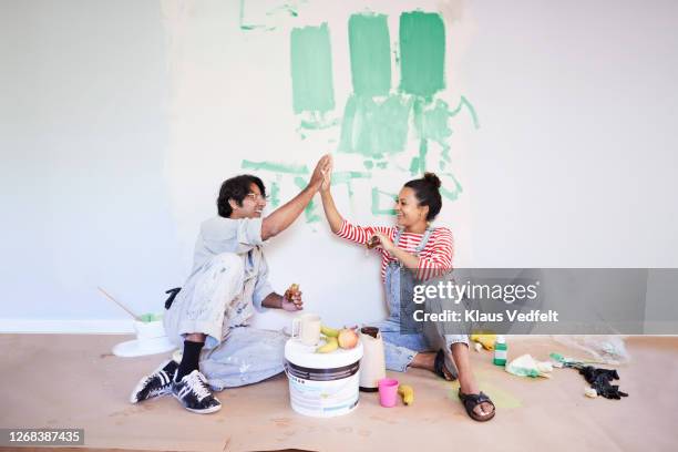 couple taking break while renovating home - pared casa fotografías e imágenes de stock
