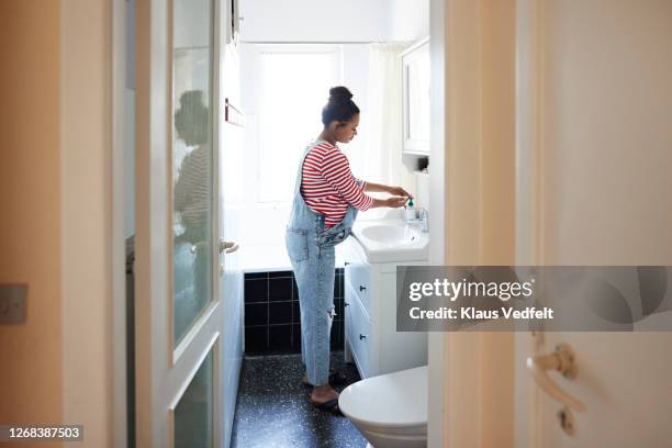 woman washing hands with disinfectant in bathroom - brightly lit bathroom stock pictures, royalty-free photos & images