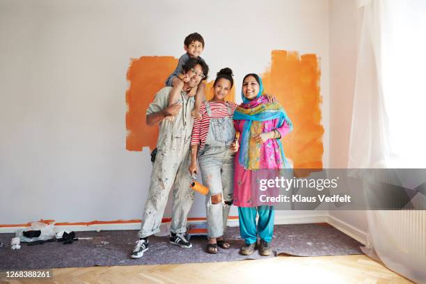 smiling family renovating home together - indian family portrait stockfoto's en -beelden